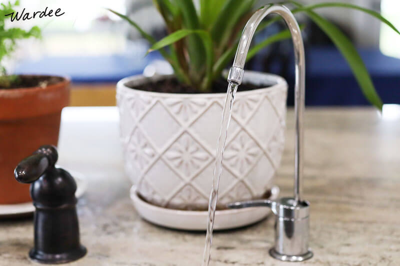 pure, filtered water coming out of a stainless steel faucet