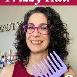 Photo of smiling woman with dark curly hair holding up a purple wide tooth comb. Text overlay says: "7 Ways to Reduce Frizzy Hair (for wavy or curly hair)"