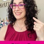 Photo of smiling woman with dark curly hair holding up a finger to point at her curls. Text overlay says: "7 Ways to Tame Frizz (+info on best styling products & tools)"