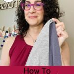 Photo of smiling woman with dark curly hair holding up a microfiber towel. Text overlay says: "7 Ways to Reduce Frizz With 7 Easy Steps (+info on best styling products & tools)"