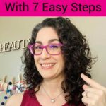 Photo of smiling woman with dark curly hair holding up a purple wide tooth comb. Text overlay says: "How to Reduce Frizz With 7 Easy Steps (no frizz halo)"