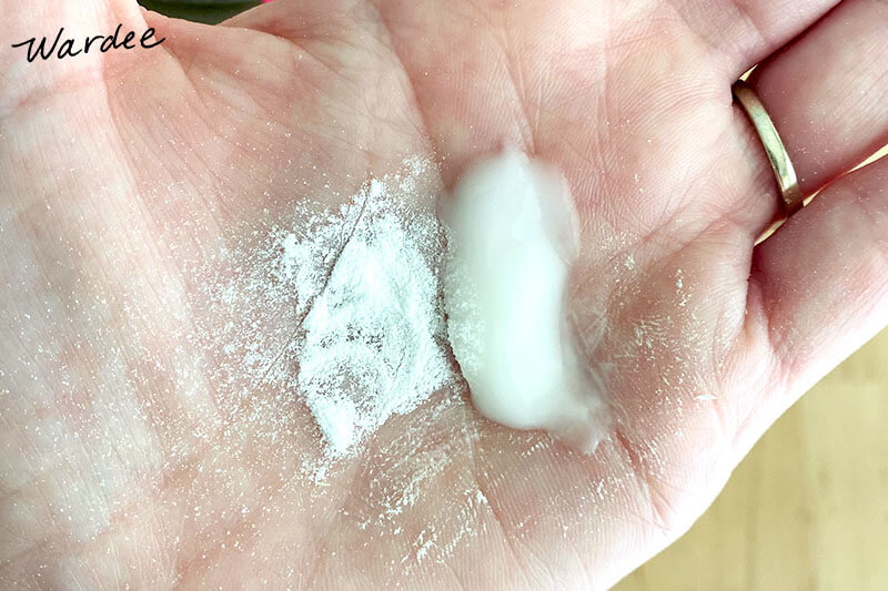 White powder and white cream side-by-side in a woman's palm.