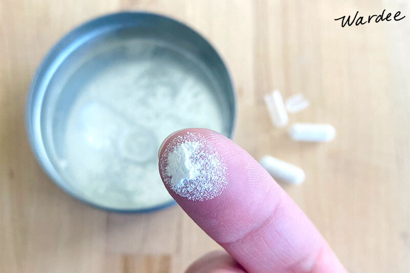 Close-up photo of white powder on a woman's fingertip.