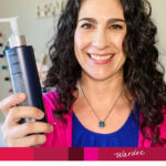 Photo of a smiling woman holding up a bottle of clarifying shampoo. Text overlay says: "Restore Soft, Shiny Hair with Clarifying Shampoo (how & why!)"