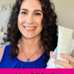 Photo of a smiling woman holding up a bottle of exfoliating scrub. Text overlay says: "How & Why to Exfoliate Skin (for better makeup & a closer shave)"