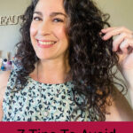 Smiling woman with dark curly hair. Text overlay says: "7 Tips to Avoid Crunchy Curls (get soft, defined, bouncy curls!)"