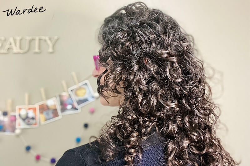 Photo of a woman with dark brown, curly hair.