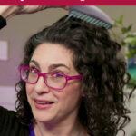 Photo of a woman with curly hair using a comb to add volume to her roots. Text overlay says: "How to Fix Soft & Limp Curls (+DIY protein treatment)"